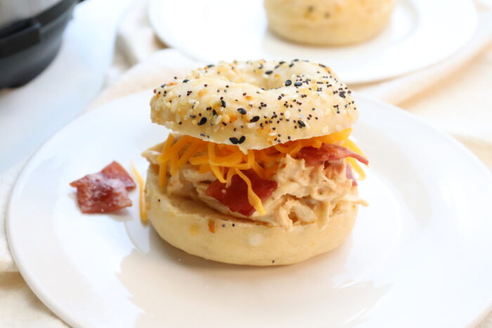 Crack Chicken served on 2 ingredient dough bagel on a white plate