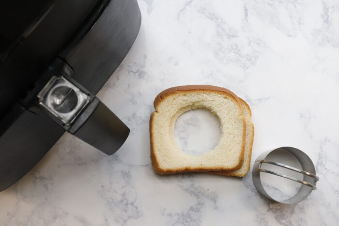 Holes cut from bread next to air fryer