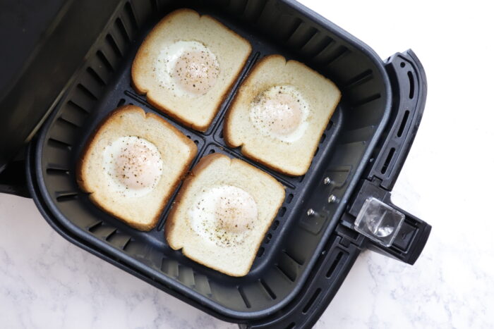 Air fryer eggs in a basket one side cooked