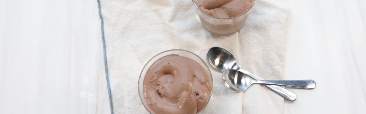 2 individual cups of Chocolate mousse next to 2 spoons