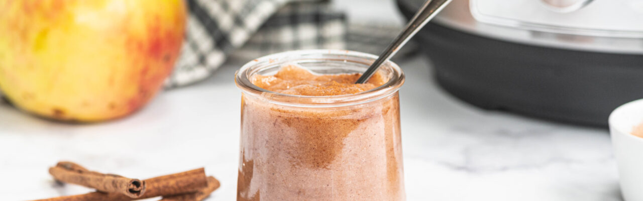 Instant pot applesauce in a glass jar with spoon