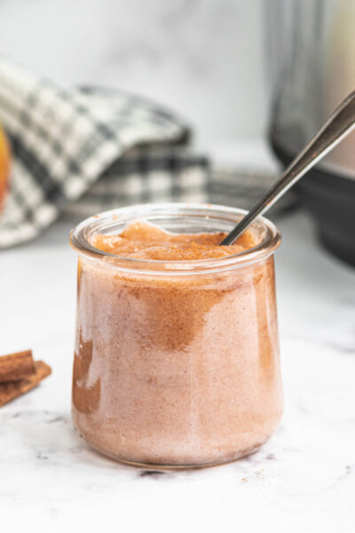 Instant pot applesauce in a glass jar with spoon
