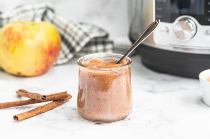 Instant pot applesauce in a glass jar with spoon