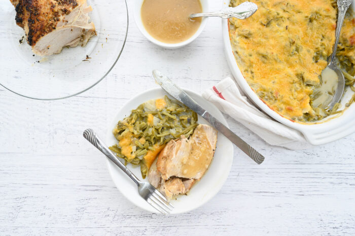 Instant pot turkey breast on white plate next to fork and knife