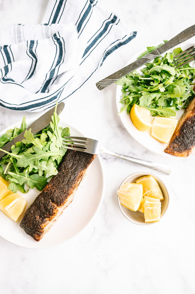 air fried salmon on two plates with salad