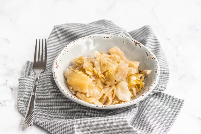 instant pot cabbage in a bowl next to fork and dish towl
