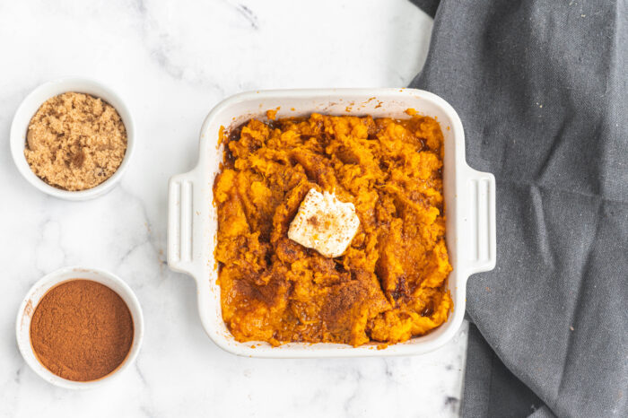 Instant pot mashed sweet potatoes in a casserole dish topped with butter