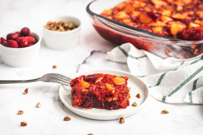 Cranberry apple salad on a plate next to casserole dish