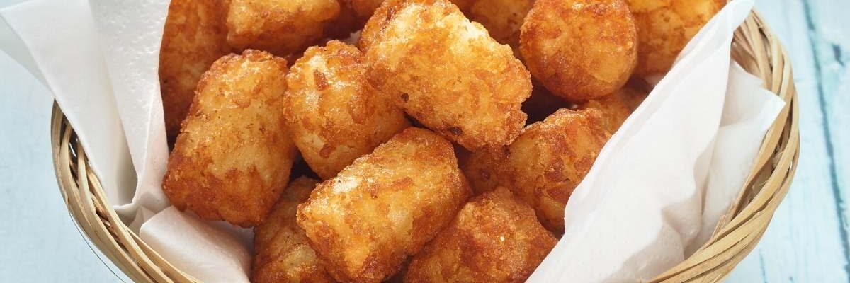 air fryer tater tots in a basket with parchment paper