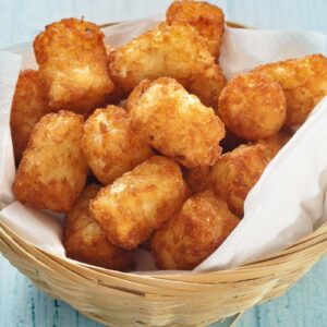 air fryer tater tots in a basket with parchment paper