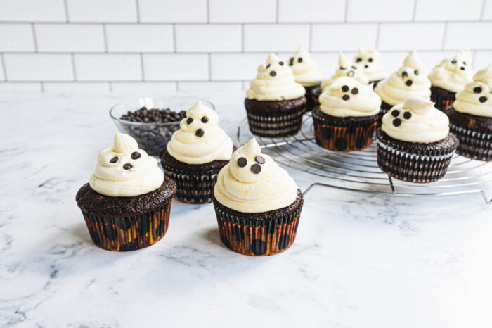 ghost cupcakes after baking next to bowl of chocolate chips