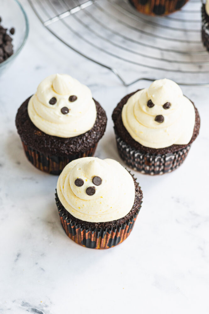 top view of halloween ghost cupcakes with chocolate chips for eyes