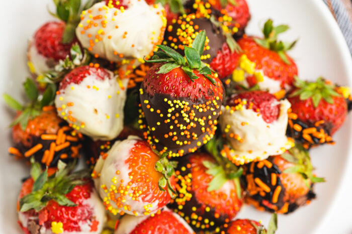 chocolate dipped strawberries for halloween topped with orange and yellow sprinkles