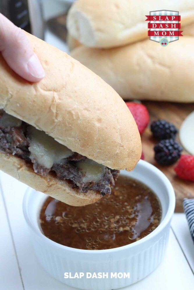 dipping instant pot french dip into ramekin of broth