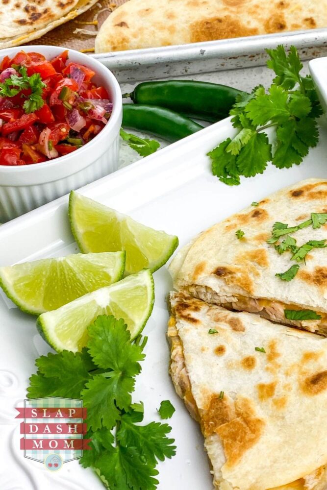 close up of air fryer quesadillas next to limes and garnish