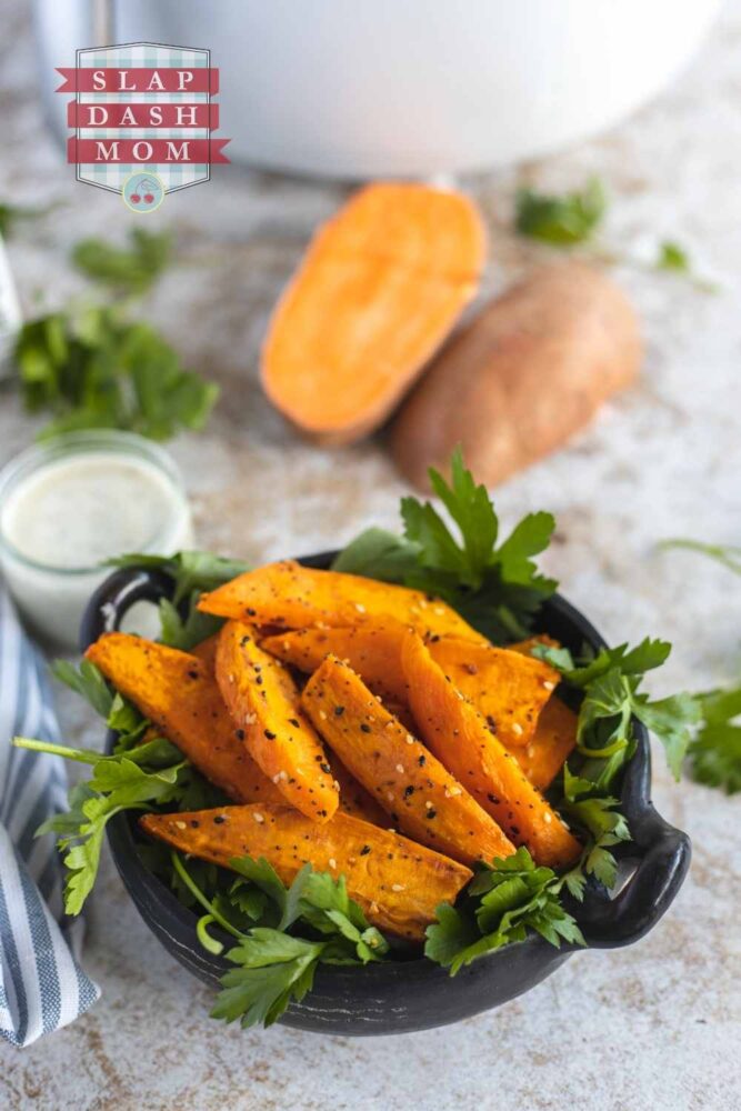 air fried sweet potato wedges in small black bowl with garnish