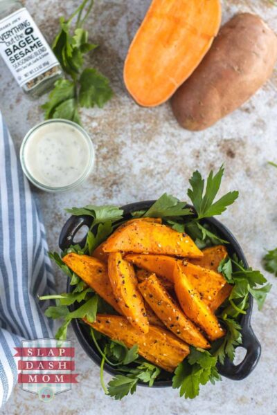 top shot of air fried sweet potato wedges next to sauce and seasoning