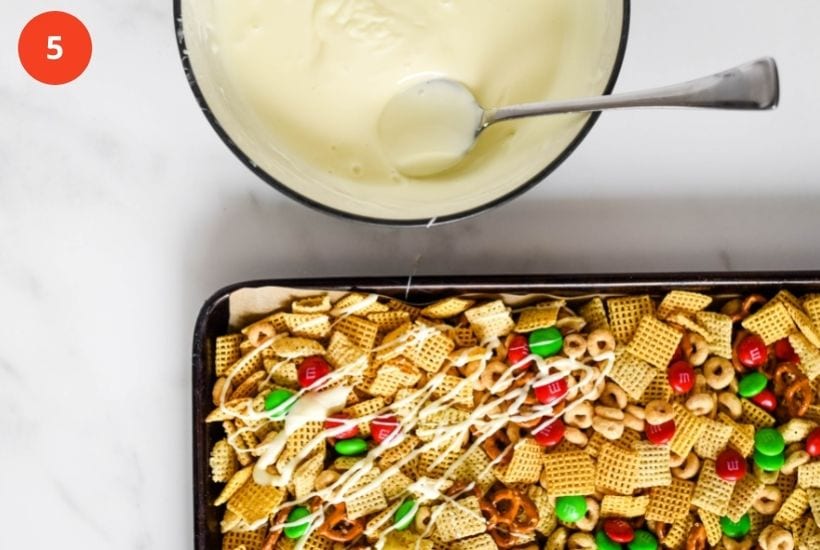 melted white chocolate being drizzled on chex mix